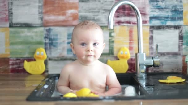 Cute Smiling Baby Taking Bath In Kitchen Sink Child Playing With Foam And Soap Bubbles In Sunny Kitchen With Rubber Ducks Little Boy Bathing Fun With Water