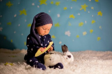 Küçük çocuk, sevimli beyaz tavşan ve bir mavi Ay'da bir bebek çocuk 