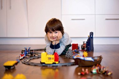 Bir oyuncak tren ile oturma odasında oynayan çocuk çocuk