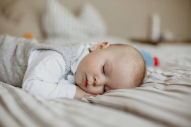 Yatak odasında büyük yatakta uyuyan küçük oğlu,