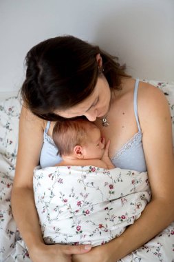 Genç anne onun yeni doğan bebek çocuk ile yatakta yalan