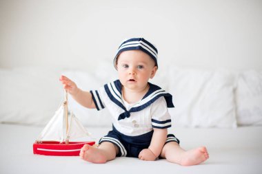 Şirin bebek çocuk, giyinmiş ahşap bo ile oynarken deniz giysili