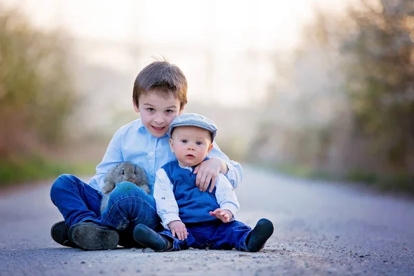 Three children, boy brothers in park, playing with little bunnie — Stock Photo, Image