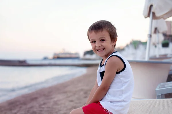 Ritratto di bambino carino, ragazzo, contemplare la spiaggia al tramonto — Foto Stock