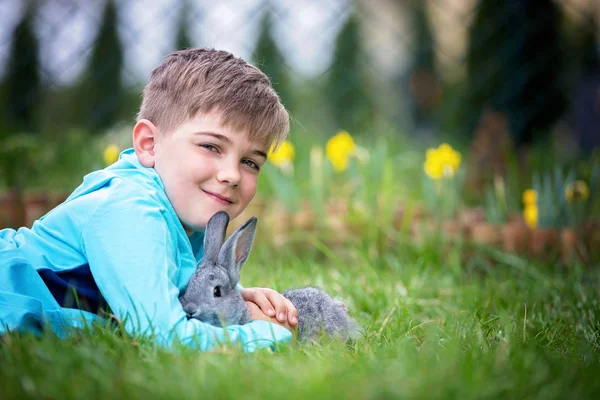 Dziecka w wieku przedszkolnym, ładny chłopiec, grając z mały królik na zewnątrz — Zdjęcie stockowe