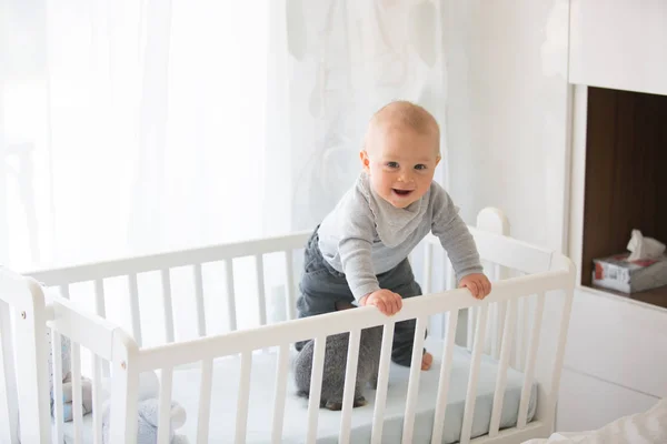 Smiling toddler boy, playing with little rabbit in crib — Stock Photo, Image