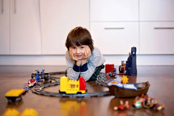 Menino brincando na sala de estar com um trem de brinquedo — Fotografia de Stock