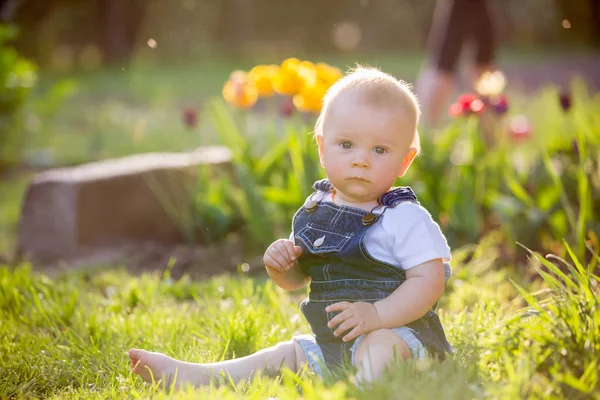 Söta barn baby pojke med sin lilla kanin, sitter i parken, s — Stockfoto