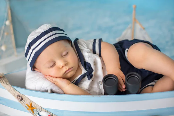 Schattig peuter babyjongen slapen in houten boot met vissen, starf — Stockfoto