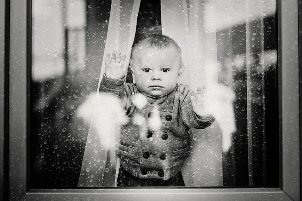 Menino bonito da criança, ficar em casa atrás das portas de vidro, watchi — Fotografia de Stock