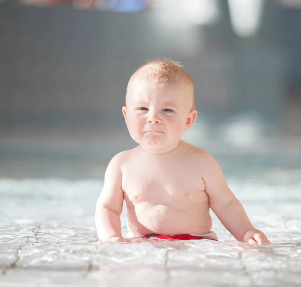 Little cute baby boy, swimming happily in a shallow pool water — Stock Photo, Image