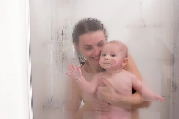 Mãe e menino no chuveiro, gotas de água — Fotografia de Stock