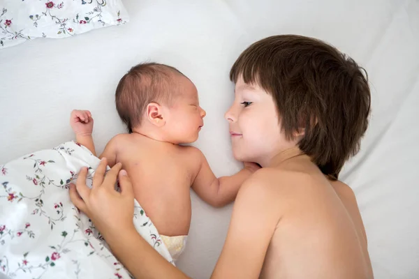 Vackra pojke, kramas med ömhet och hand sin nyfödda baby — Stockfoto