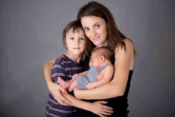 Imagen familiar de dos niños y su madre, besándose y abrazándose — Foto de Stock