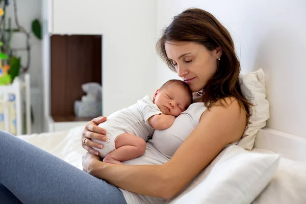 Joven madre acostada en la cama con su bebé recién nacido — Foto de Stock