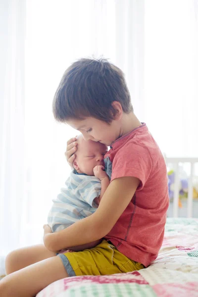 Süße Vorschulkind, umarmt mit Zärtlichkeit und kümmert sich um seine kleine — Stockfoto