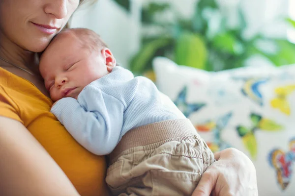 Joven madre, sosteniendo tiernamente a su bebé recién nacido — Foto de Stock