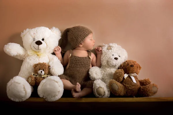 Newborn baby boy wearing a brown knitted bear hat and pants, sle — Stock Photo, Image