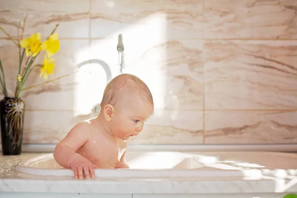 甘い男の子は、朝の時間をキッチンでシンクにシャワーを浴びて — ストック写真
