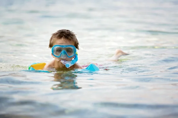 Aranyos fiú úszás védőszemüveg és úszhat a tengerben légzőcső — Stock Fotó