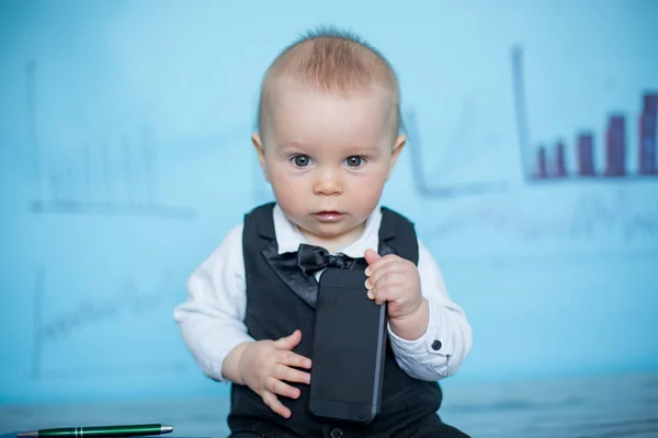 Menino bonito, vestido de terno e arco, falando ao telefone — Fotografia de Stock