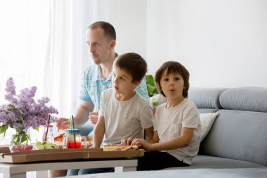 Baba ve onun iki erkek, çocuk, evde pizza yiyip watc