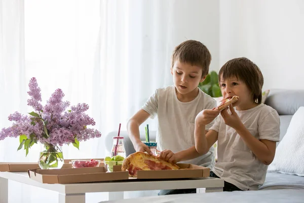 Bela família jovem com crianças, comer pizza em casa e w — Fotografia de Stock