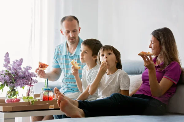 Schöne junge Familie mit Kindern, Pizza essen zu Hause und w — Stockfoto
