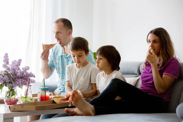 Beautiful young family with children, eating pizza at home and w — Stock Photo, Image
