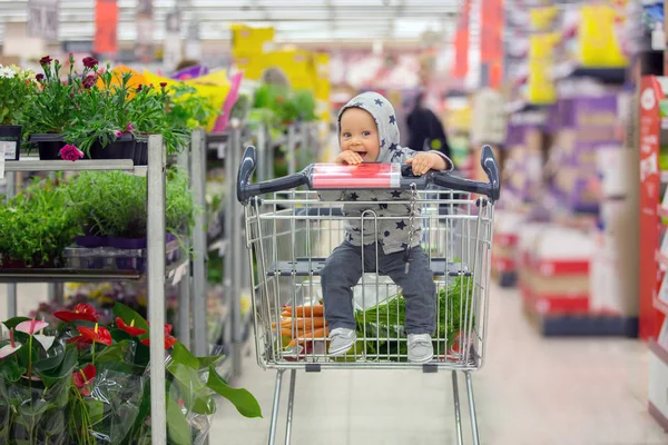 Мальчик, сидящий в картонке в продуктовом магазине, s — стоковое фото