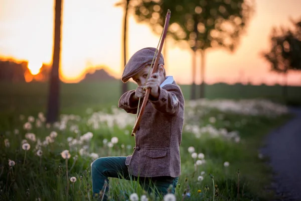 Портрет ребенка, играющего с луком и стрелами, стрельба из лука — стоковое фото