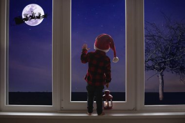 Küçük çocuk büyük bir Fransız kapısının önünde duruyor, eğiliyor...