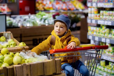 Sırt çantalı, süpermarketten alışveriş yapan yeni yetme bir çocuk.