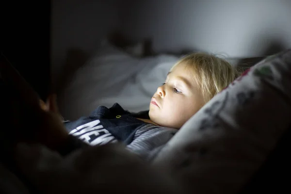 Happy peuter jongen kijken nachten verhaal 's nachts op tablet — Stockfoto