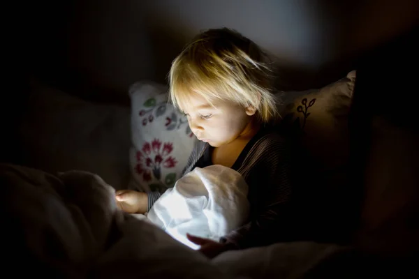 Happy peuter jongen kijken nachten verhaal 's nachts op tablet — Stockfoto