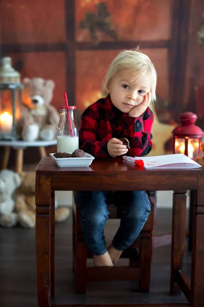 可爱的金发碧眼的小男孩，给圣诞老人写信，祝愿他早熟 — 图库照片