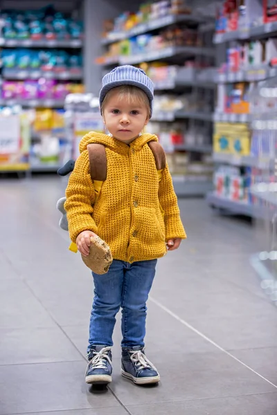 Fashion toddler boy with backpack, shopping in supermarket — Stock Photo, Image