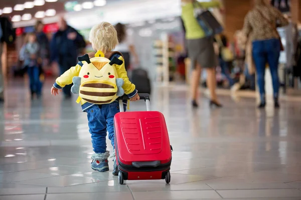 Netter kleiner Junge wartet auf den Flug in der Transithalle des Flughafens — Stockfoto