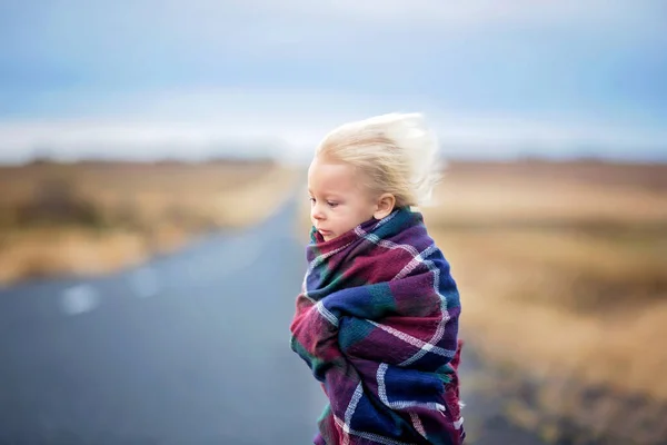 風の強い日に道路に立って美しい子供は、包まれた — ストック写真