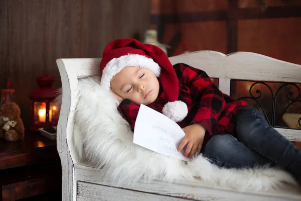 Süße blonde Kleinkind Junge, schlafend mit Brief an Weihnachtsmann in der Hand, — Stockfoto