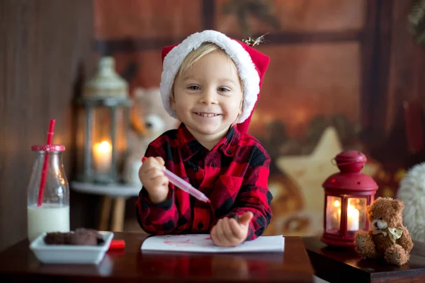 Doux garçon blond tout-petit, écrivant une lettre au Père Noël, souhaitant prese — Photo