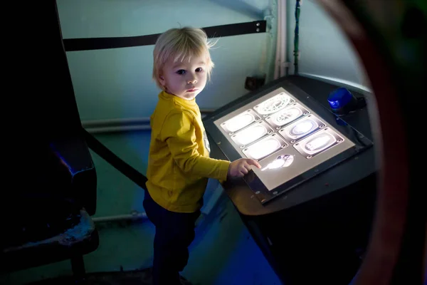 Kleiner kleiner Junge in einem Raumschiff, beleuchtetes Bedienfeld, — Stockfoto