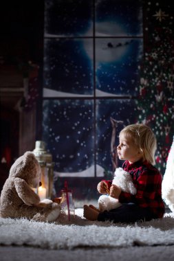 Tatlı çocuk, Noel gecesi evde kitap okuyor.