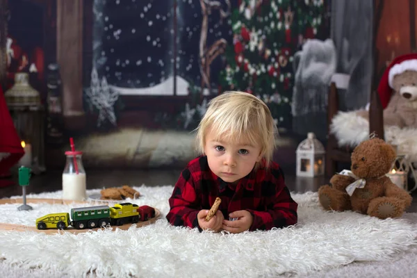 Söta barn pojke, leka med trä tåg hemma på natten på — Stockfoto