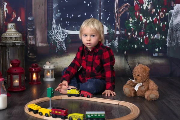 Dulce niño, jugando con el tren de madera en casa por la noche en —  Fotos de Stock