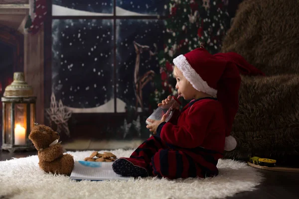 Söta barn pojke, läsa bok hemma på natten på julen — Stockfoto