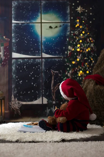 甘い幼児の男の子、クリスマスの夜に家で本を読む — ストック写真