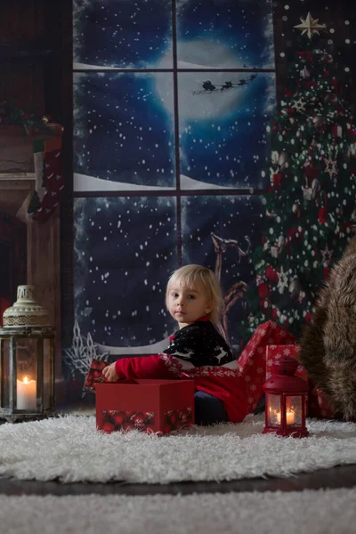 Hermoso niño pequeño, regalos de apertura en la noche de Navidad, secr —  Fotos de Stock