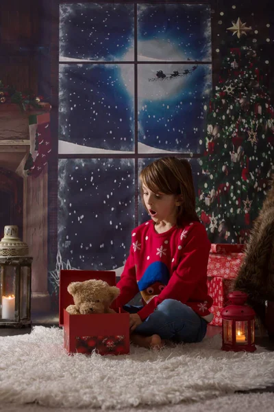 Vackra barn skolpojke, öppna presenter på julafton — Stockfoto