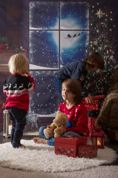 Красивые дети, открывающие подарки в Рождественскую ночь, secretl — стоковое фото